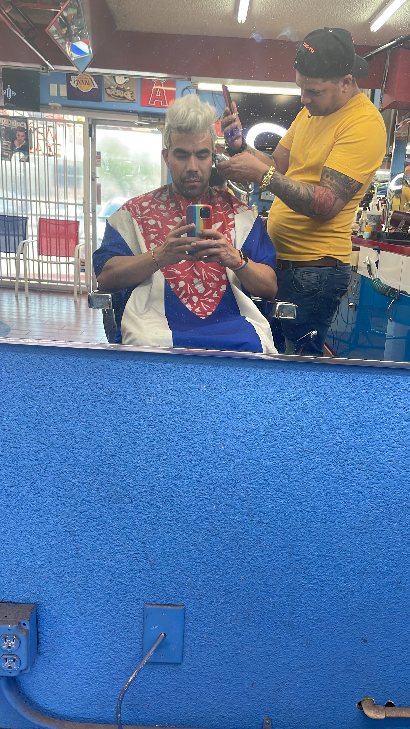 Barber cutting a client's hair in the shop, mirror selfie view