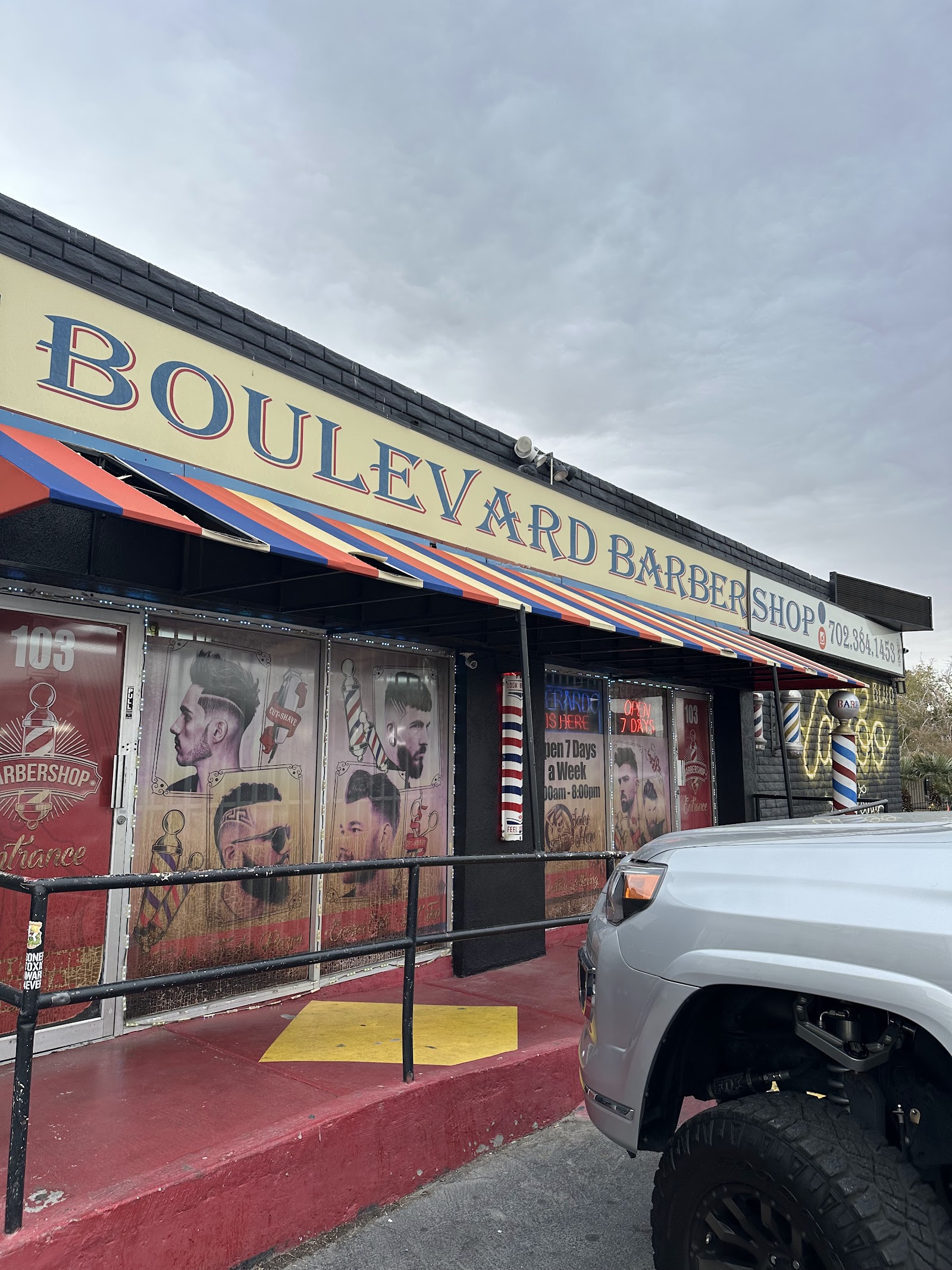 Boulevard Barber Shop exterior with striped awning and barber pole